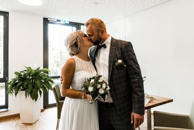 Ein Mann und eine Frau stehen in einem Raum - Gelenk, Hochzeitskleid, Schulter, Kuss, Braut, Pflanze, Kleid, Brautkleid, Blitzfotografie, glücklich